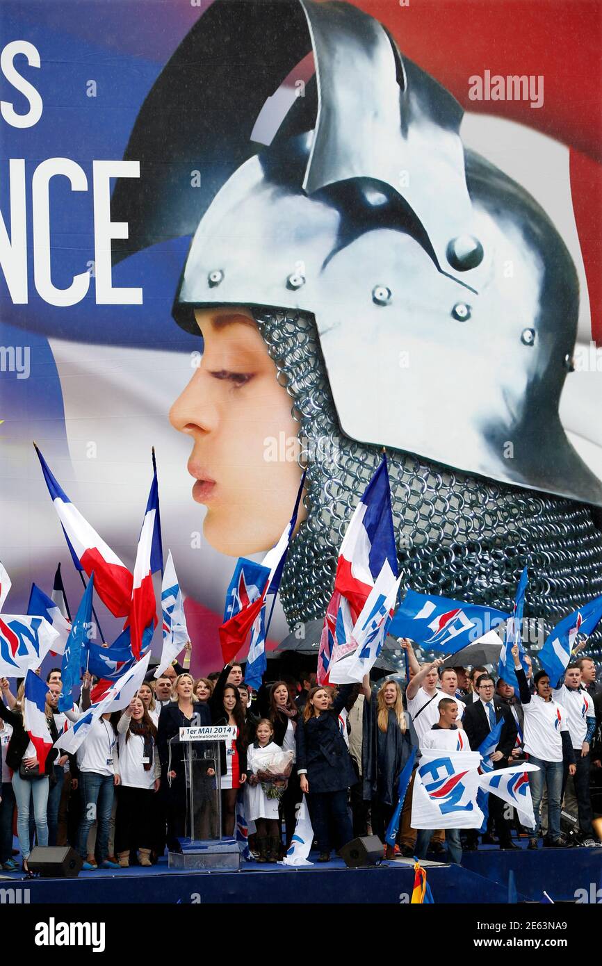 France's far right National Front political party leader Marine Le Pen is  surrounded by supporters in front of a giant poster of Jeanne d'Arc (Joan  of Arc) during the National Front's annual