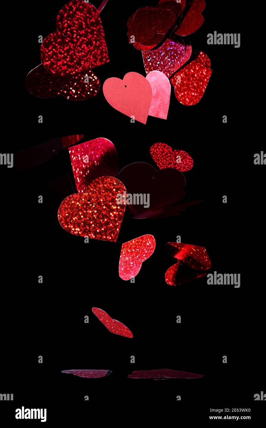 Reflective red hearts, falling on black background Stock Photo - Alamy