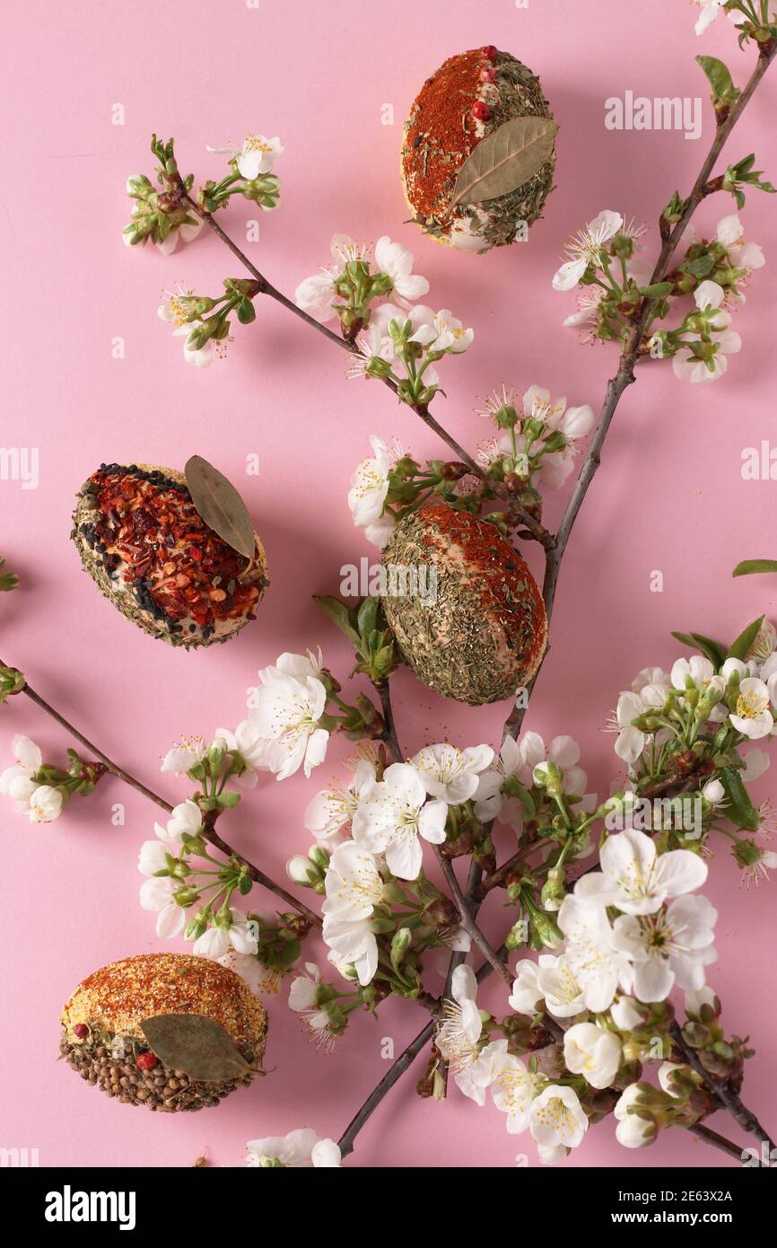 Easter concept with eggs decorated with different spices and cereals without dyes and preservatives on pink background. Vertical format Stock Photo