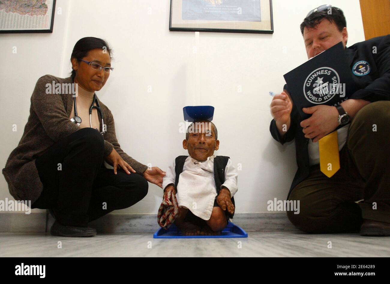 Chandra Bahadur Dangi, 72, who claims to be the world's shortest man  standing at a height of 22 inches (56 centimeters), is measured by the  Editor-in-Chief of Guinness World Record Craig Glenday (