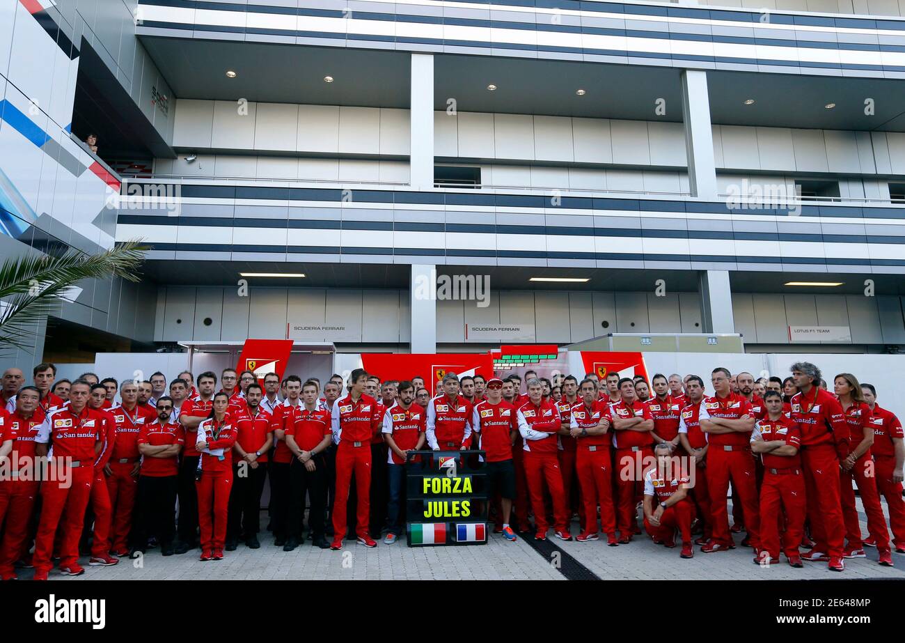 Members of Ferrari Formula One team pose with a sign in support of Marussia Formula One driver Jules Bianchi of France before the first Russian Grand Prix in Sochi October 12, 2014. Formula One drivers have backed proposals to introduce a 'virtual safety car' or automatic speed limiter that would force the entire field to slow when yellow warning flags are waved. The idea was raised by race director Charlie Whiting at the Russian Grand Prix on Saturday as one of the measures being considered following Bianchi's horrific crash in Japan last weekend. REUTERS/Laszlo Balogh (RUSSIA - Tags: SPORT M Stock Photo