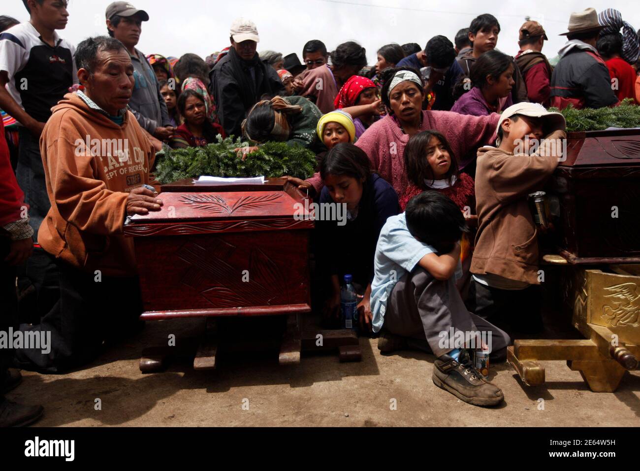 Relatives cry next to coffins during the funeral of 13 victims of a landslide in the village of Parrasquin in Nahuala, September 6, 2010. A massive landslide buried a crowd trying to dig out a bus from deep mud on Sunday, killing at least 22 people, with dozens more feared dead, as torrential rains battered Guatemala. REUTERS/Edgard Garrido(GUATEMALA - Tags: DISASTER SOCIETY) Stock Photo