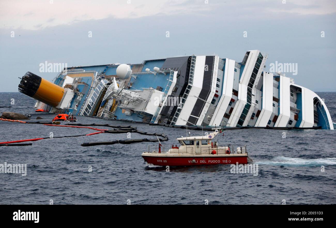 A fire brigade boat goes past the capsized cruise liner Costa Concordia off the west coast of Italy at Giglio island February 2, 2012.  Royal Caribbean Cruises Ltd, the world's second-largest cruise operator, warned that earnings in the current quarter could fall by as much as 50 percent as the Costa Concordia disaster off the coast of Italy caused a sharp drop-off in new cruise bookings.  Royal Caribbean shares fell as much as 5.7 percent on Thursday morning but later pared losses to trade down 0.8 percent at $28.01 on the New York Stock Exchange.  REUTERS/Darrin Zammit Lupi (ITALY - Tags: DI Stock Photo