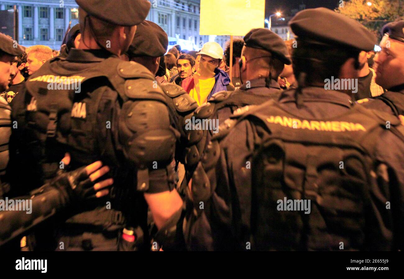 A demonstrator confronts gendarmes trying to block protesters from marching on one of Bucharest's main boulevards September 5, 2013. Roughly 1,000 people gathered in the Romanian capital late on Thursday for a fifth day of protests against plans to start an open-cast gold mine in the small Carpathian town of Rosia Montana. The catalyst for the protests, which started on Sunday when thousands of people took to the streets in cities across Romania, was a move by the leftist government last week to approve a draft bill allowing the project to go ahead.  REUTERS/Radu Sigheti (ROMANIA - Tags: BUSIN Stock Photo
