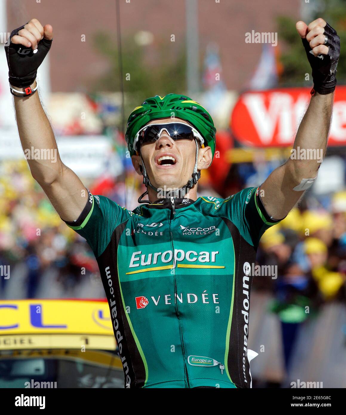 Europcar rider Pierre Rolland of France kisses a mascot on the podium  wearing the best young white jersey after the 20th time trial stage in  Grenoble, during the Tour de France cycling