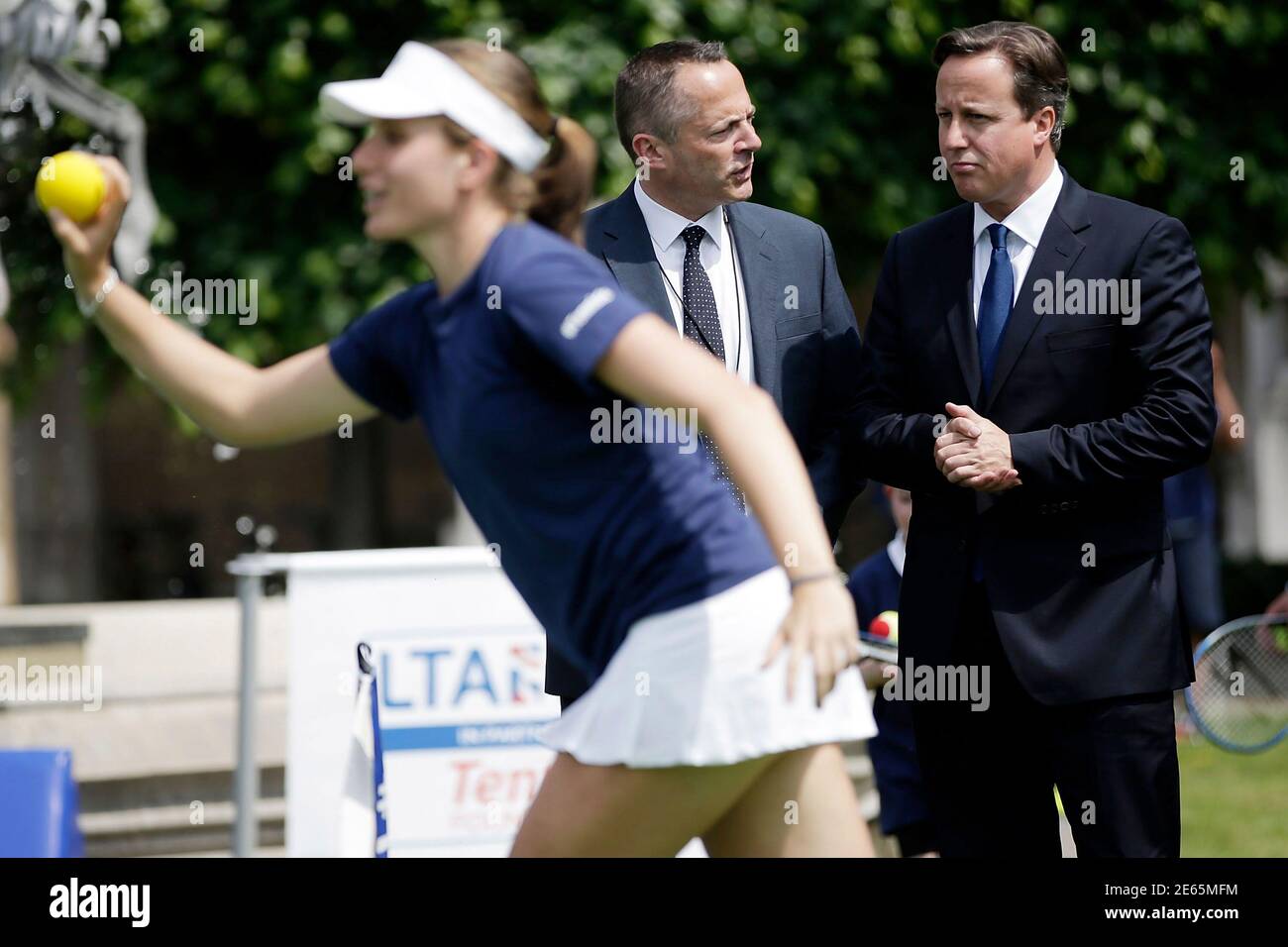 Britain's Prime Minister David Cameron (R) watches as British Number 3 female Johanna Konta plays with children at an event in the grounds of the Houses of Parliament in London June 19, 2013. The Wimbeldon tennis championships are held June 24 to July 7. REUTERS/Matthew Lloyd/POOL  (BRITAIN - Tags: SPORT TENNIS POLITICS) Stock Photo