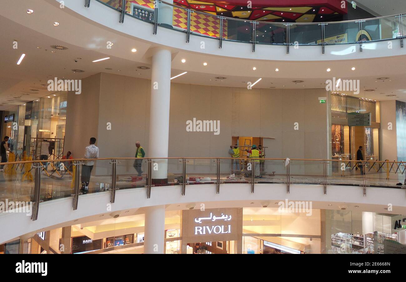 Employees of Bahrain City Center block a Rolex outlet during early hours of  morning in Manama, September 11, 2013. Thieves broke into the shop late  night of September 10, stealing Rolex watches