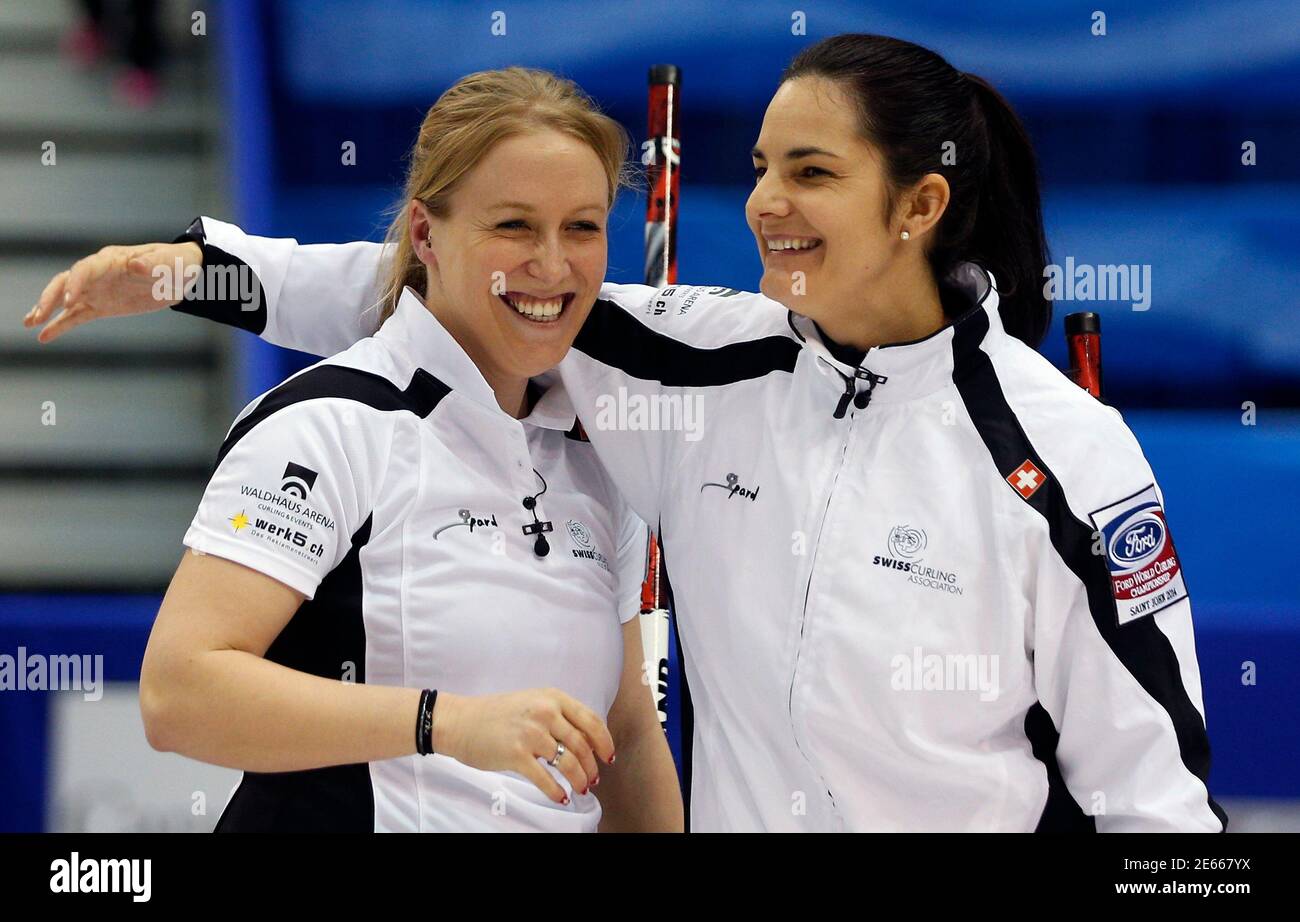 Switzerland's third Irene Schori (L) and skip Binia Feltscher celebrate  after defeating South Korea during their semi-final game at the World  Women's Curling Championships in Saint John, New Brunswick, March 22, 2014.