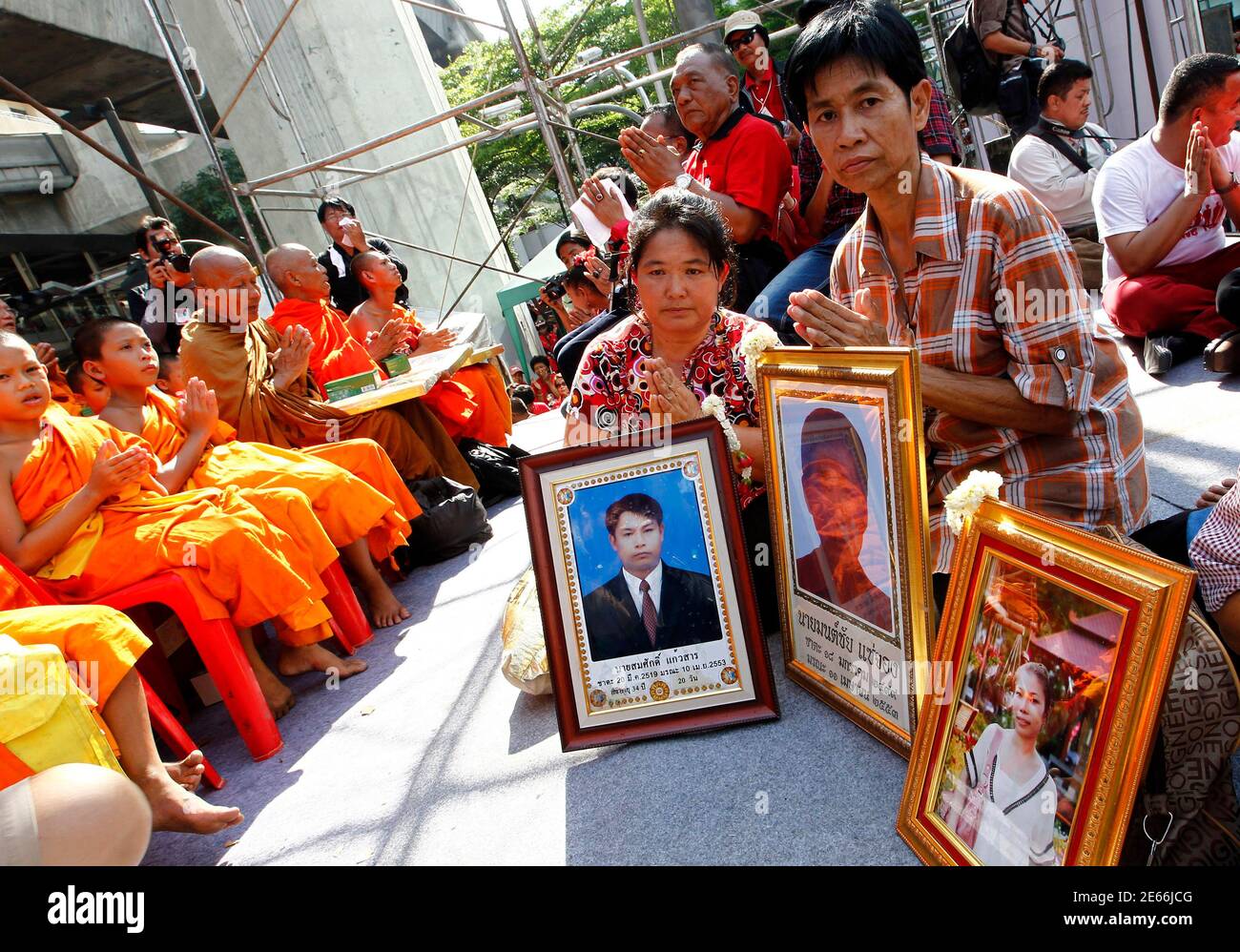 Relatives pray for their loved ones who lost their lives in the government crackdown on red shirt protesters during a gathering to mark its second anniversary at Ratchaprasong intersection in Bangkok May 19, 2012. Red shirts gathered to mark the two year anniversary of a government crack down that left 91 people dead and over 2,000 injured.  REUTERS/Sukree Sukplang (THAILAND - Tags: POLITICS CIVIL UNREST) Stock Photo