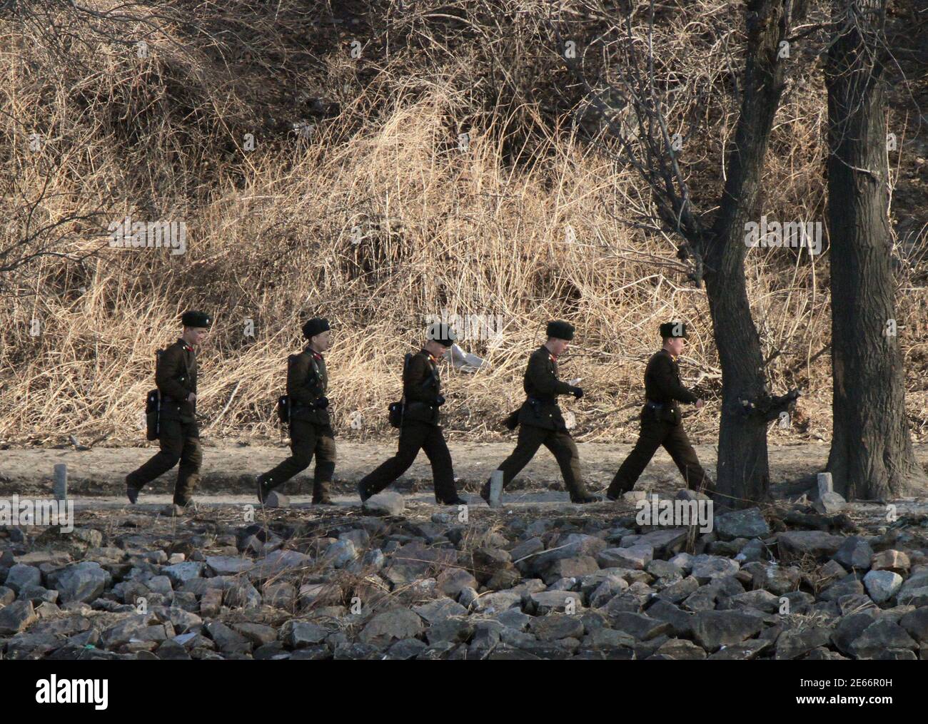 North Korean soldiers patrol along the bank of Yalu River near the North Korean town of Sinuiju, opposite the Chinese border city of Dandong, February 4, 2014. Picture taken February 4, 2014. REUTERS/Jacky Chen (NORTH KOREA - Tags: MILITARY POLITICS) Stock Photo