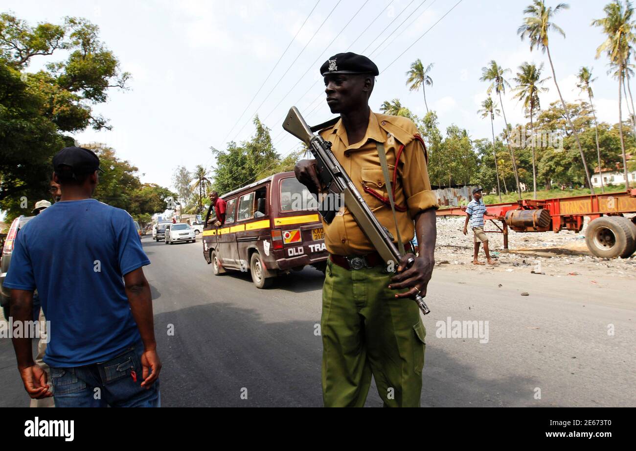 A policeman holds his gun as he patrols along the streets of the Kenyan coastal city of Mombasa, August 29, 2012. Kenya's prime minister said on Wednesday the country's enemies were behind the killing of a Muslim cleric that triggered riots he described as being conducted by an 'underground organisation' to create divisions between Christians and Muslims. REUTERS/Thomas Mukoya (KENYA - Tags: SOCIETY RELIGION CIVIL UNREST POLITICS) Stock Photo
