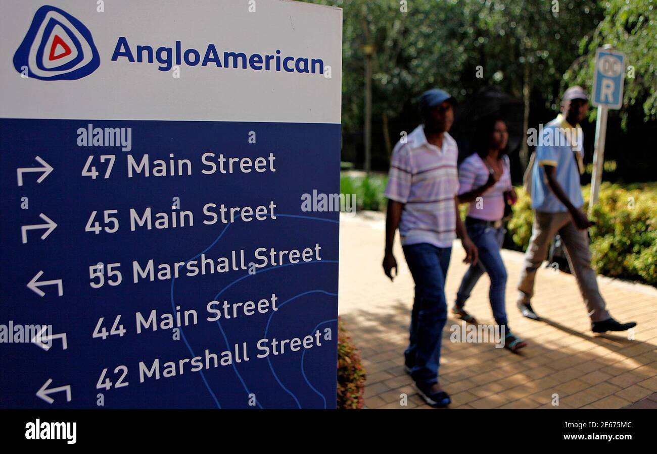 People walk past a board outside the Anglo American offices in Johannesburg January 8, 2013. Australian mining executive Mark Cutifani, a one-time coal miner, has been appointed chief executive of Anglo American, taking on what analysts and investors say is one of the toughest jobs in the business. Cutifani, who will step down as chief executive of Johannesburg-based AngloGold in March, had been one of several outsiders in the running for the top job at Anglo after Cynthia Carroll quit in October. He was named as a frontrunner over the weekend.  REUTERS/Siphiwe Sibeko (SOUTH AFRICA - Tags: BUS Stock Photo