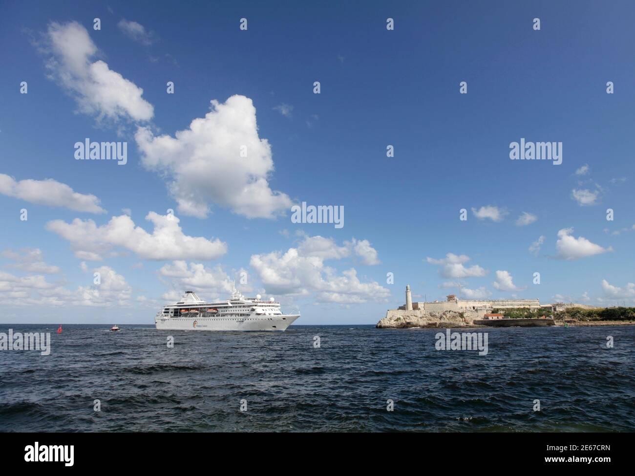 Spanish cruise ship 'Gemini' passes by the lighthouse of the colonial fortress Morro Cabana as it enters Havana Harbor November 12, 2010. Spanish company Happy Cruises will home-port its 'Gemini' ship in Havana and will offer around-Cuba cruises.  REUTERS/Desmond Boylan (CUBA - Tags: SOCIETY TRAVEL BUSINESS) Stock Photo