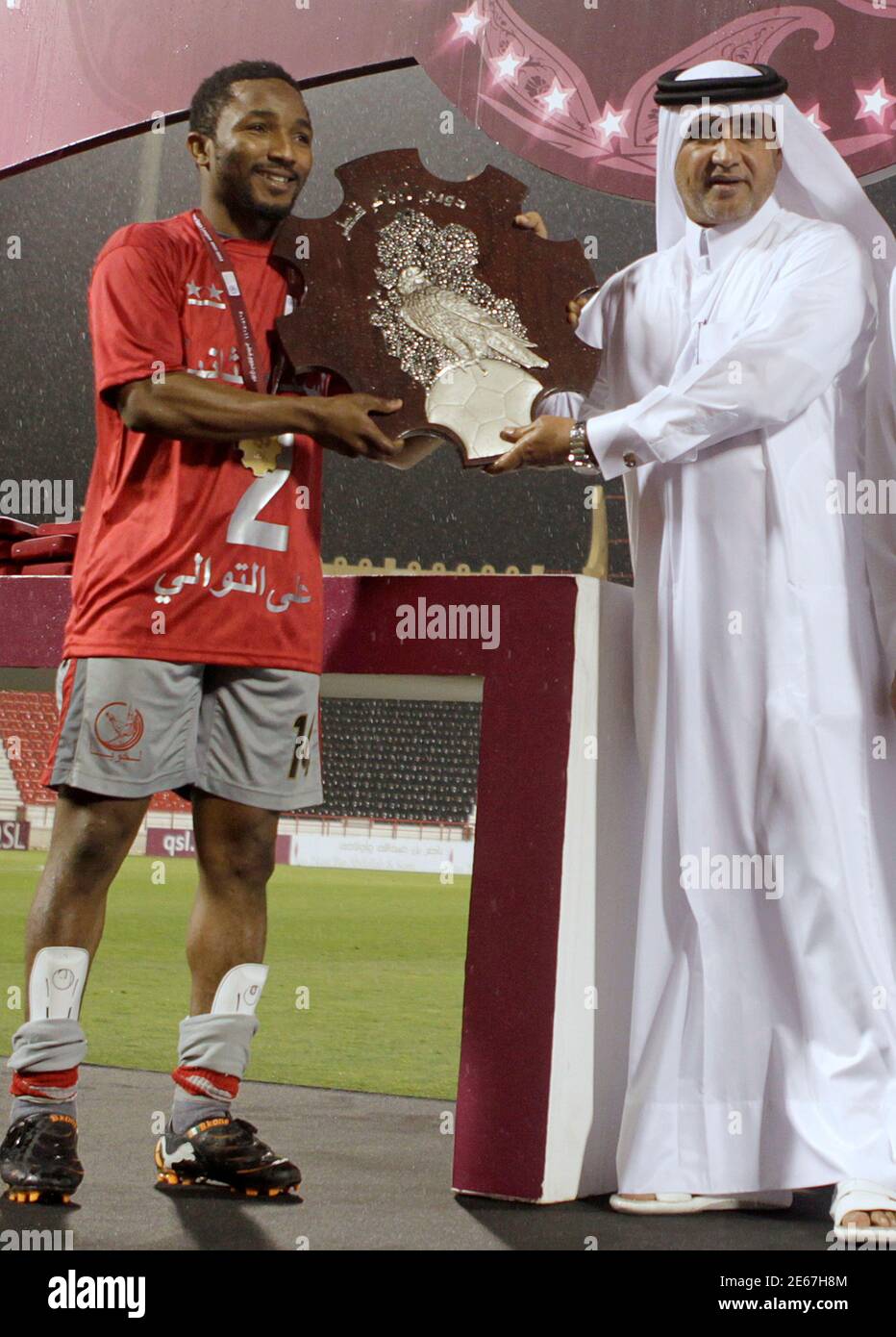 Lekhwiya S Bakari Kone L Of Ivory Coast Receives The League Trophy From General Secretary Of The Qatar Football Association Saud Abdulaziz Al Mohannadi After Their Qatar Stars League Soccer Match Against Al Rayyan