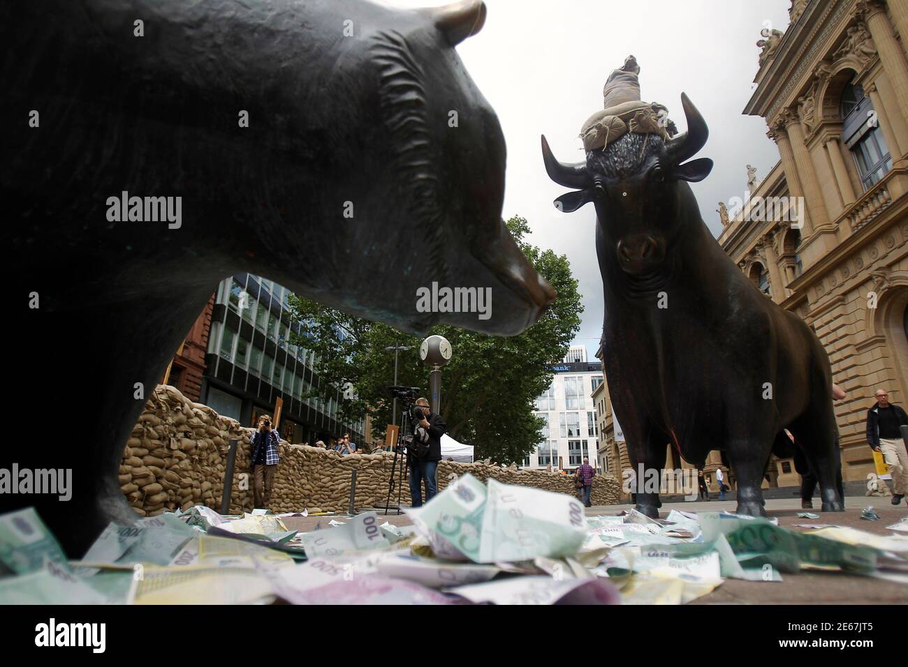 Bull and bear statues are surrounded by fake bank notes during a protest against financial speculations in front of Frankfurt's stock exchange June 17, 2012. REUTERS/Alex Domanski (GERMANY - Tags: BUSINESS CIVIL UNREST) Stock Photo