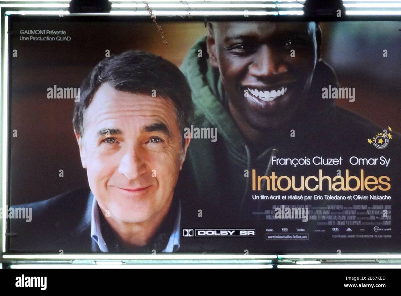 French actors Francois Cluzet (L) and Omar Sy (R) are seen on the movie  poster of the film "Intouchables" at a movie theatre in Paris January 3,  2012. Cluzet plays the role
