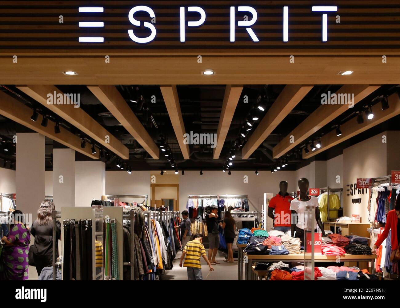 People shop at an Esprit Outlet store in Singapore September 10, 2013.  Clothing retailer Esprit Holdings Ltd posted on Tuesday a  deeper-than-expected net loss for fiscal 2013, weighed down by weakness in