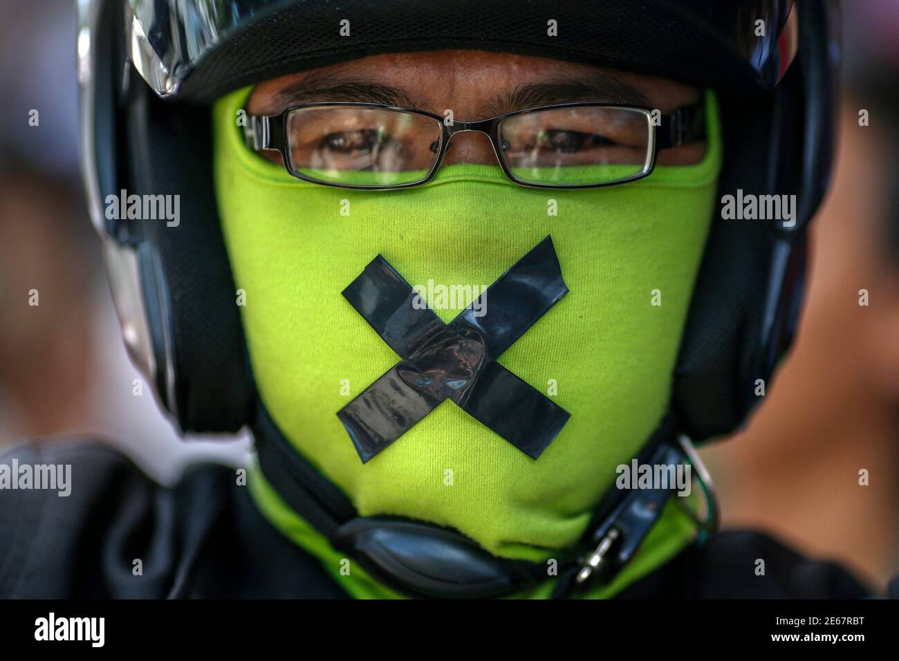 A man who covered his face and his mouth taped up attends a protest against military rule in Bangkok May 24, 2014. Former Prime Minister Yingluck Shinawatra was in a 'safe place' on Saturday, an aide said, after being held by Thailand's army following its seizure of power this week, as opposition to the coup grew among her supporters and pro-democracy activists. REUTERS/Athit Perawongmetha  (THAILAND - Tags: POLITICS CIVIL UNREST) Stock Photo