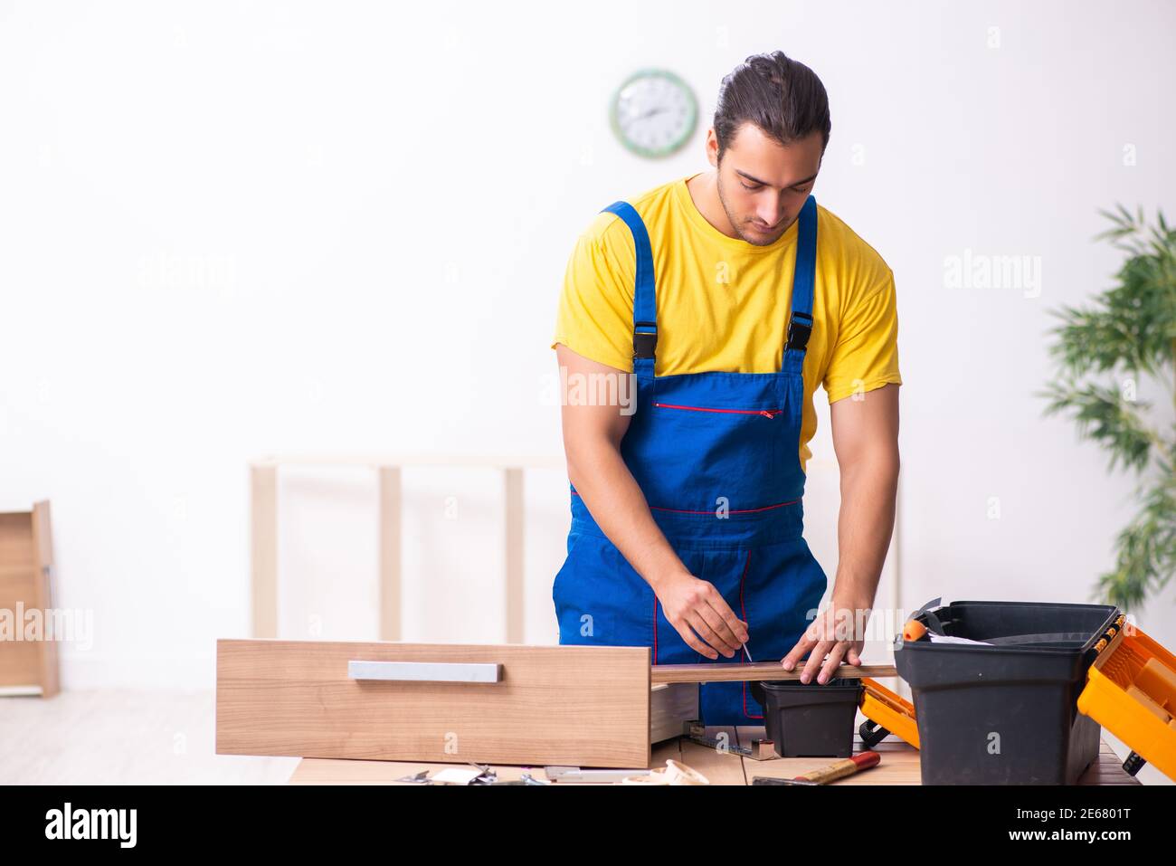 Young male carpenter working indoors at home Stock Photo - Alamy