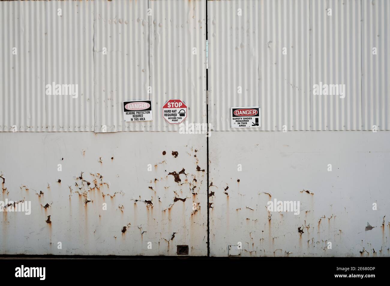 Safety equipment required warning signs on warehouse doors in