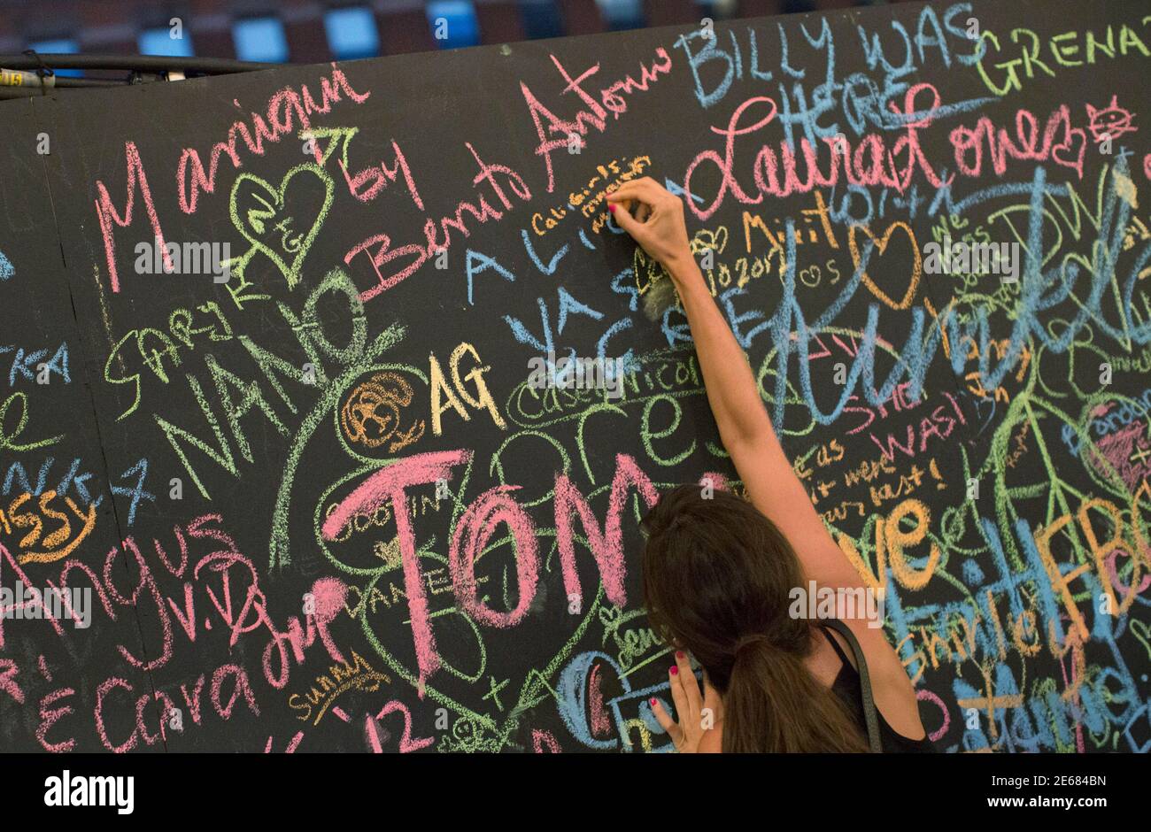 A woman adds her name to a chalkboard erected for Fashion's Night Out in New York's Meatpacking District September 6, 2012. Fashion's Night Out began in 2009 as a means to encourage consumers to shop and support the fashion industry during the tough economic climate. REUTERS/Andrew Kelly (UNITED STATES - Tags: FASHION) Stock Photo