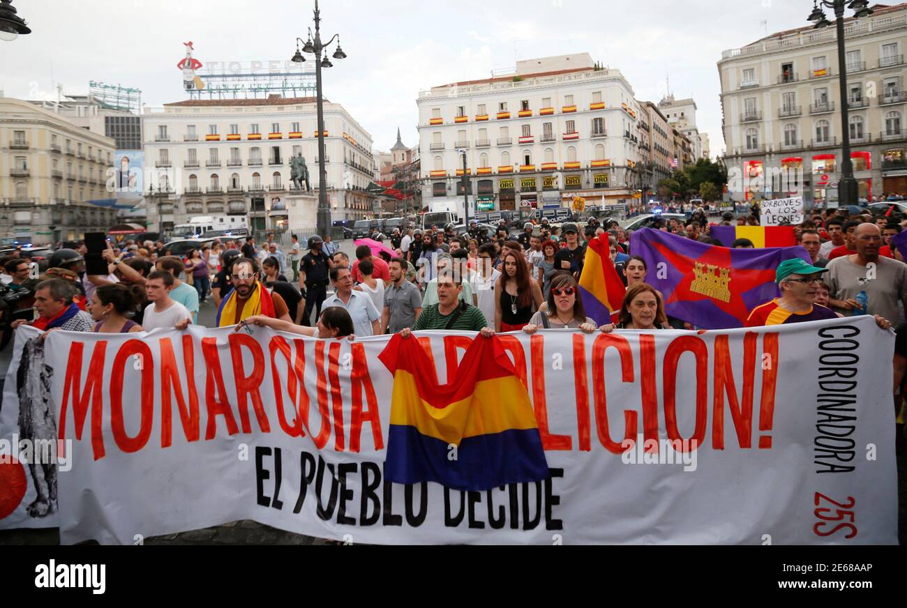 Anti-monarchy demonstrators hold a banner which reads 'Monarchy abolition! People decided!' during a Republican protest, after the swearing-in ceremony of Spain's new King Felipe VI in Madrid, at the landmark Puerta del Sol square in Madrid June 19, 2014. Spain's new king, Felipe VI, was sworn in on Thursday in a low-key ceremony which monarchists hope will usher in a new era of popularity for the troubled royal household. REUTERS/Gonzalo Fuentes (SPAIN - Tags: CIVIL UNREST POLITICS ROYALS) Stock Photo