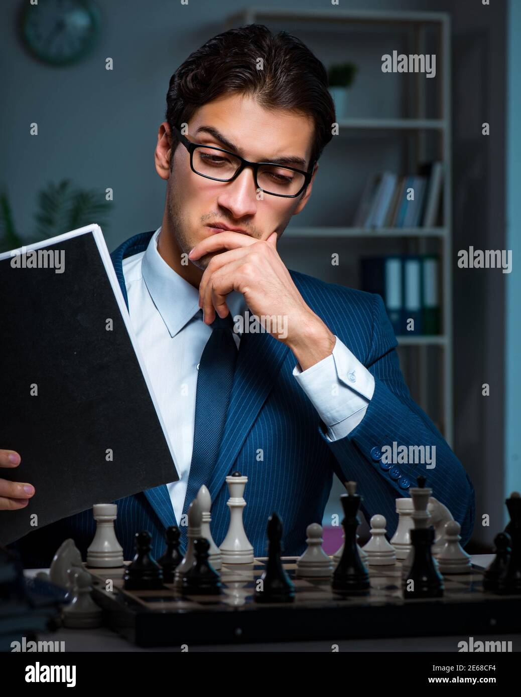 The businessman playing chess in strategy concept Stock Photo - Alamy