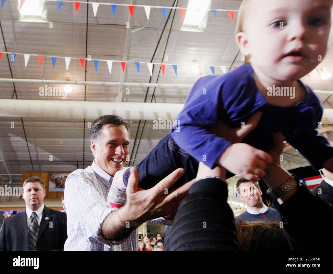 Republican presidential candidate Mitt Romney hands Madison Busch, 1, to her mother after a campaign event at an RV dealer in Loveland, Colorado February 7, 2012. The Colorado caucuses take place today. REUTERS/Rick Wilking (UNITED STATES - Tags: POLITICS) Stock Photo