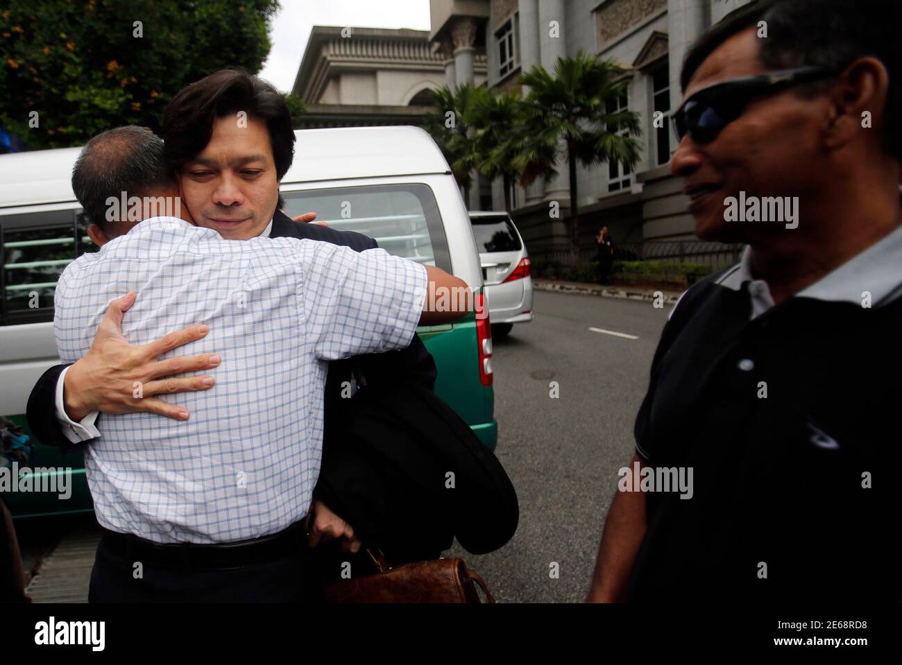 The lawyer of Malaysia's former police special action unit personnel Sirul Azhar Umar and Azilah Hadri, Kamarul Hisham Kamarudin (C), is hugged by Sirul Azhar's uncle, Mustaffa Samad, as Sirul Azhar's brother looks on, outside the courthouse in Putrajaya near Kuala Lumpur August 23, 2013. The Court of Appeal on Friday overturned the conviction of Sirul Azhar and Azilah, who were accused of the murder of Mongolian model Altantuya Shaariibuu, according to local media. In 2009, the two officers were convicted and sentenced to death by the High Court for killing the Mongolian woman in 2006. REUTER Stock Photo