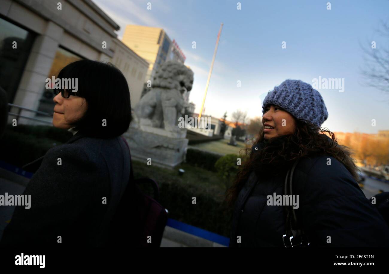Liu Fei (R), a 41-year-old warehouse worker, and her lawyer Huang Yizhi wait to enter a courthouse for a hearing in Fangshan, district of Beijing, December 6, 2013. Chinese warehouse worker Liu Fei was fined 330,000 yuan ($54,200), or 14 times her yearly wage, for having a second child and her failure to pay means the boy has no access to basic rights like schooling and healthcare. Liu's desperation prompted a fruitless attempt to sell her kidney and her eight-year-old boy's plea to sell his instead. Their dilemma has now triggered a rare legal battle against the police for denying the boy a ' Stock Photo