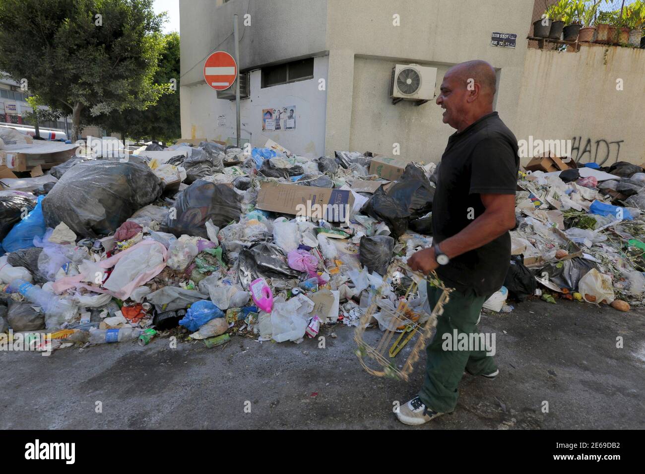 A man walks past a pile of garbage along a street in Beirut, Lebanon July  22, 2015. The streets of Beirut are quickly becoming host to growing  mountain of garbage after a