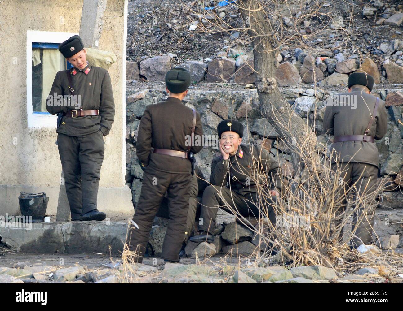 North Korean soldiers talk on the banks of the Yalu River, near the North Korean town of Sinuiju, opposite the Chinese border city of Dandong, November 23, 2010. China expressed worry about reports that North Korea had shelled a South Korean island on  Tuesday in the latest escalation of tensions on the Korean peninsula that neigbours the world's second-biggest economy.  . REUTERS/Stringer (NORTH KOREA - Tags: POLITICS ENERGY MILITARY IMAGES OF THE DAY) Stock Photo