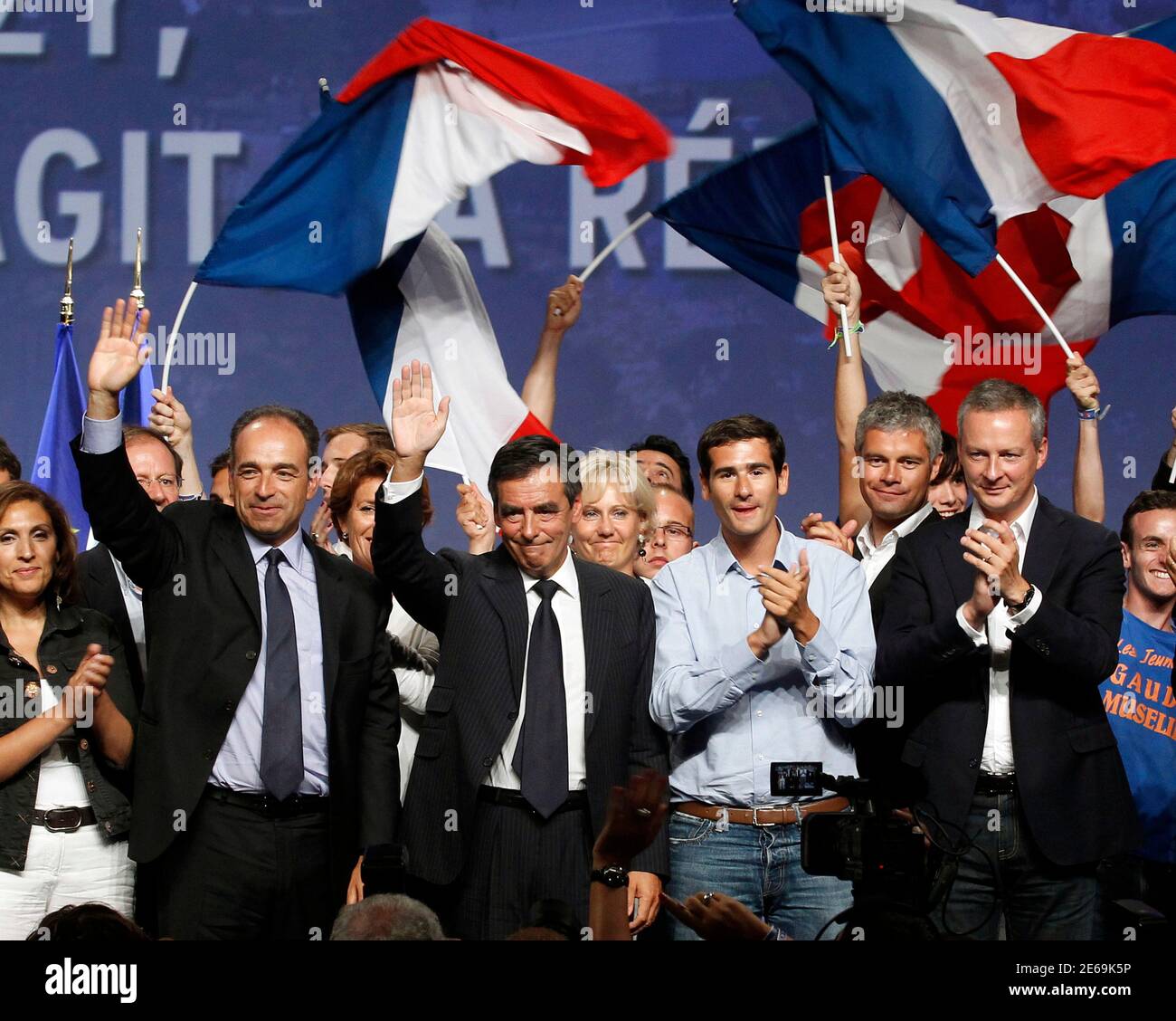 UMP political party leader Jean-Francois Cope (L) and Prime Minister Francois  Fillon (2nd L) wave to supporters as UMP Youth Popular movement President  Benjamin Lancar (2nd R) and Agriculture Minister Bruno Le