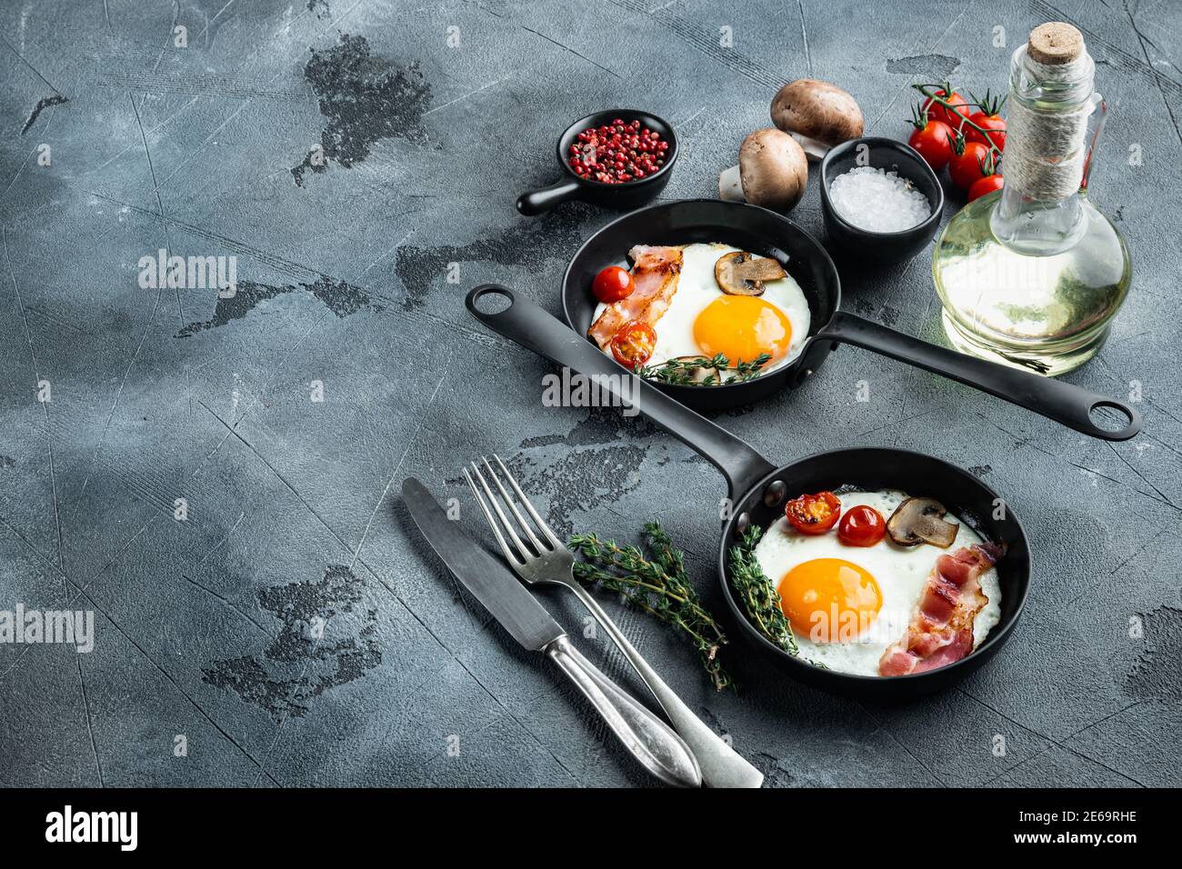 Fried Egg with ingredients in cast iron frying pan, on gray background