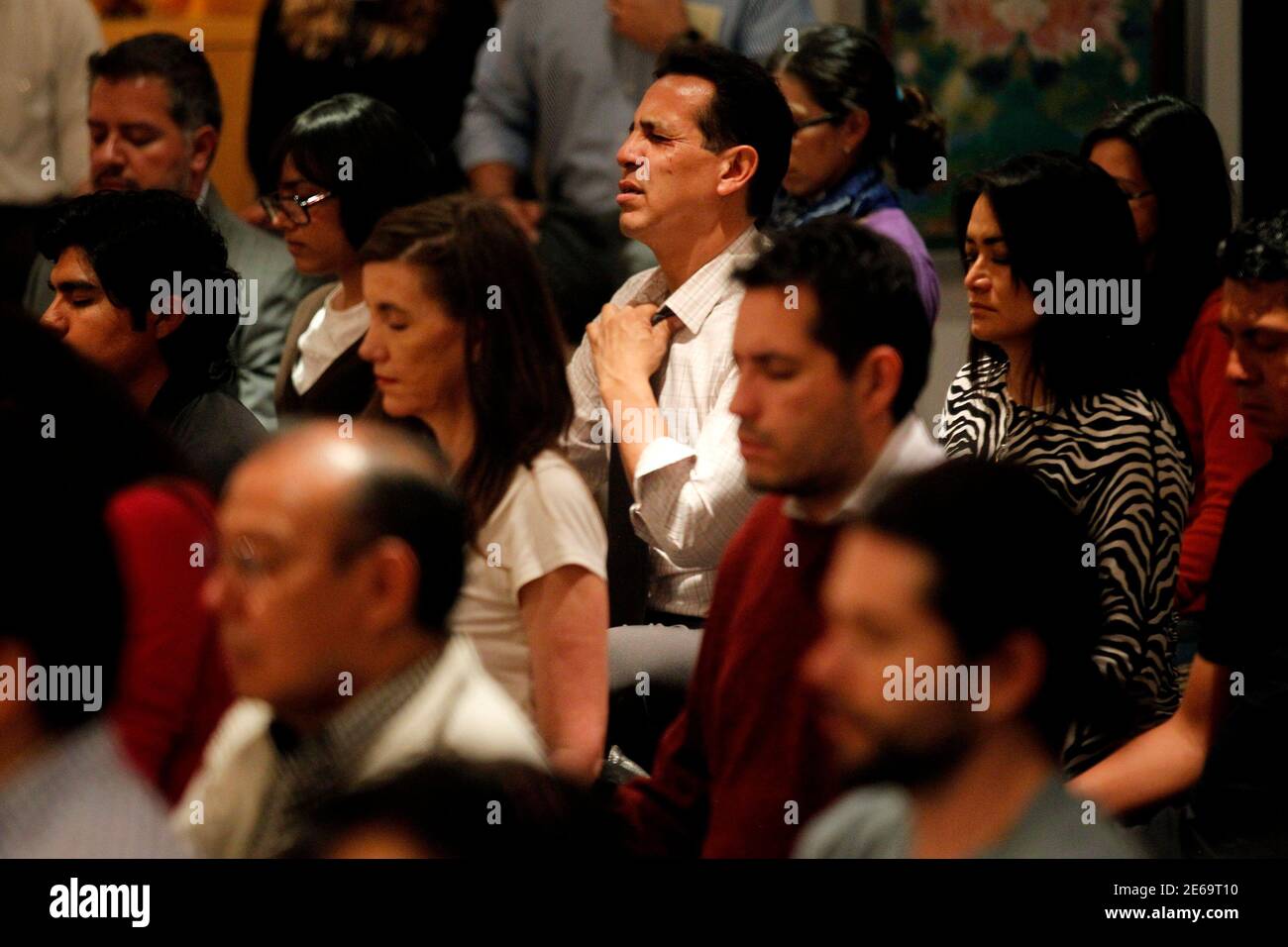 Mexican students of the Tibetan Buddhist culture meditate inside Tibet house in Mexico City, October 7, 2013. The Dalai Lama will visit Mexico from October 11 to 16. Picture taken October 7, 2013. REUTERS/Edgard Garrido (MEXICO - Tags: RELIGION ) Stock Photo