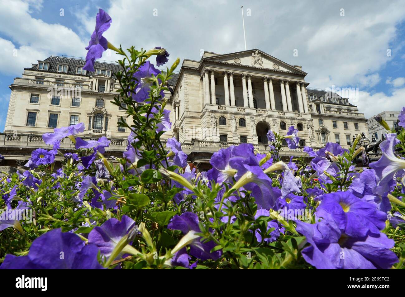 Flowers bloom in front of the Bank of England in the City of London August 6, 2013. British manufacturing grew much more strongly than expected in June, suggesting the country's recovery is broadening just as the Bank of England prepares to set out its plan for steering the economy back to health. Car sales also rose, house prices continued to climb and British retailers had their best month since 2006. REUTERS/Toby Melville (BRITAIN - Tags: BUSINESS) Stock Photo