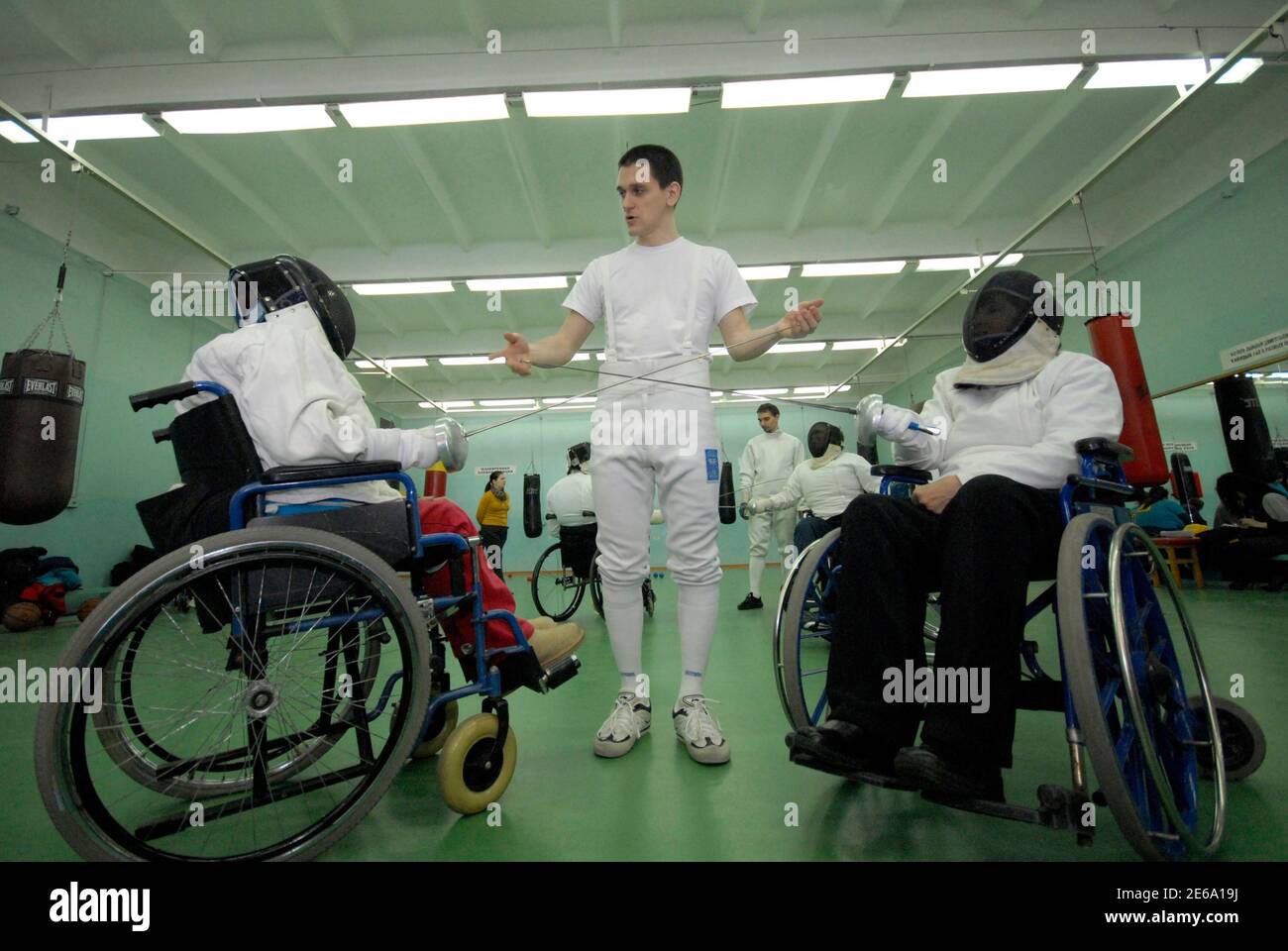 A trainer instructs disabled people during a wheelchair fencing training session in Russia's far eastern city of Vladivostok March 11, 2011. The Kovcheg (Ark) organisation, which supports handicapped people, and local authorities held a series of sporting events to popularise Paralympic sports.  REUTERS/Yuri Maltsev  (RUSSIA - Tags: SPORT HEALTH FENCING OLYMPICS) Stock Photo