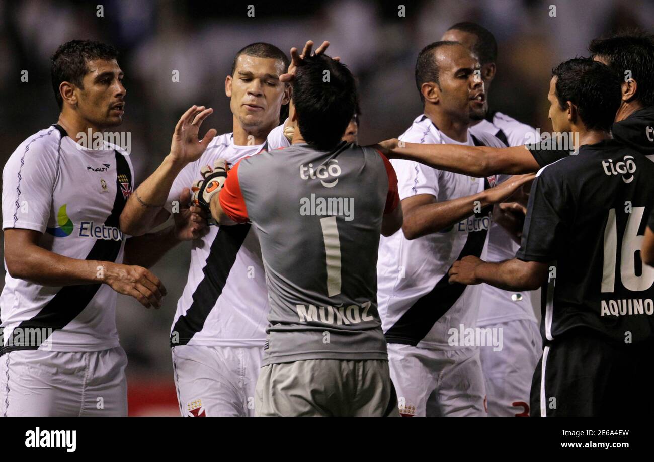 Nilton (2nd L) of Vasco da Gama hits goalkeeper Rodrigo Munoz (1) of  Paraguay's Libertad after referee Enrique Osses (unseen) ejected him with a red  card during their Copa Libertadores soccer match