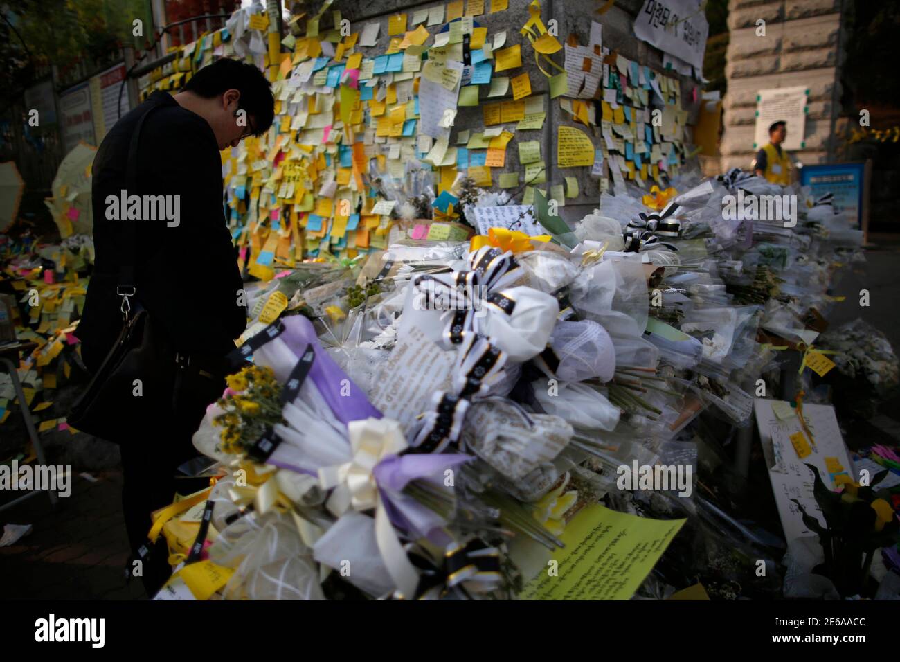 A man pays tribute as he reads messages for victims of the capsized passenger ship Sewol at the main gate of Danwon high school in Ansan April 25, 2014. The Sewol ferry, weighing almost 7,000 tons, sank on a routine trip from the port of Incheon, near Seoul, to the southern holiday island of Jeju. Investigations are focused on human error and mechanical failure. REUTERS/Issei Kato (SOUTH KOREA - Tags: DISASTER MARITIME TPX IMAGES OF THE DAY) Stock Photo