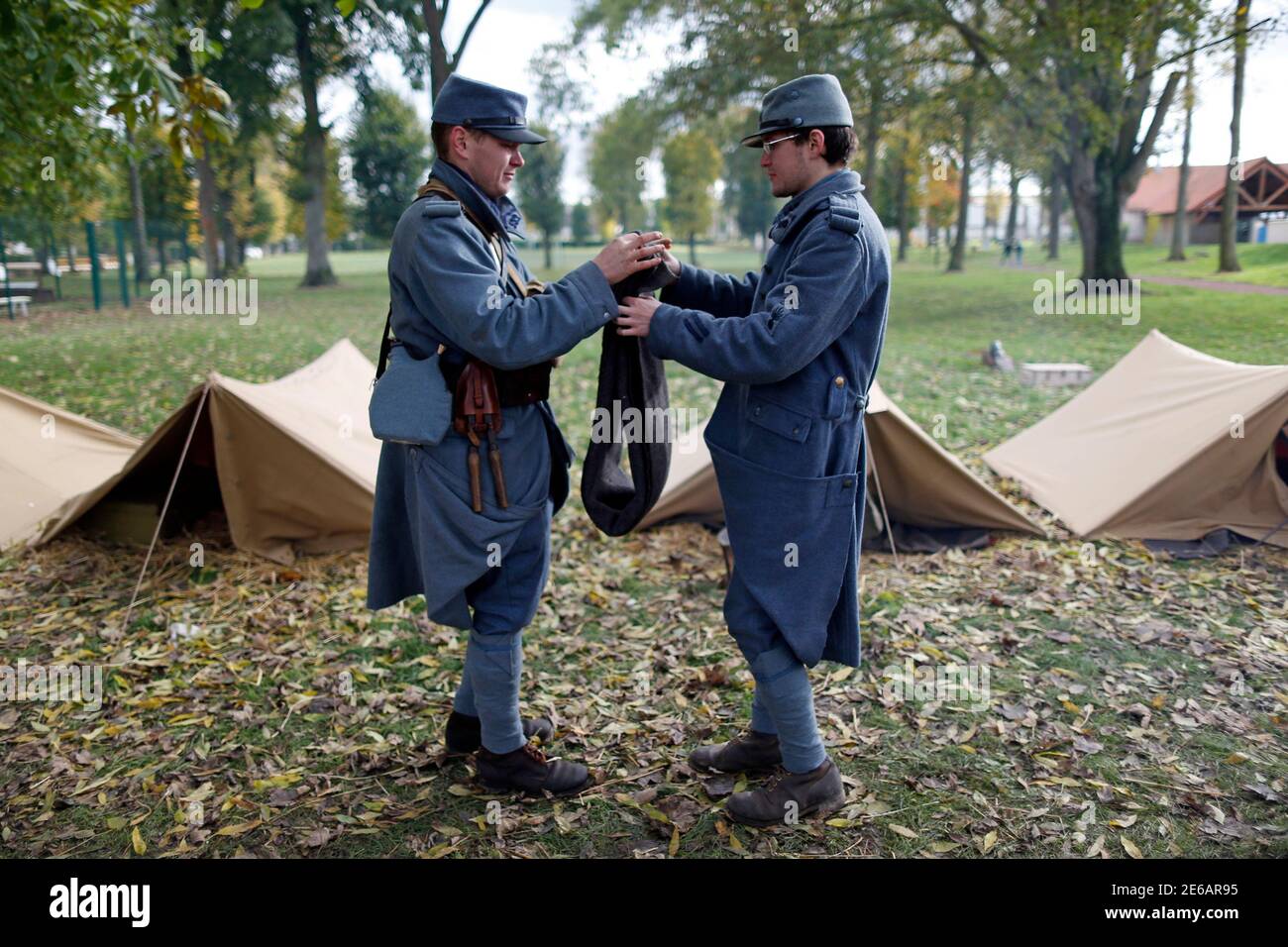 World War One Historical Association '14-18 en Somme' members Guillaume (L) and Andy, dressed with vintage army uniforms as Poilu (French soldier in World War I) fold a blanket at their bivouac camp in Fouilloy, Northern France, November 10, 2013. The historical association '14-18 en Somme' was created in August 2009 by French history teacher Sylvain Pinard with the aim of keeping alive the memory of the soldiers of World War One, and promoting understanding of the battles of the Great War. Armed with their motto 'Never forget, always remember', the 30 members live, eat and sleep in the same c Stock Photo