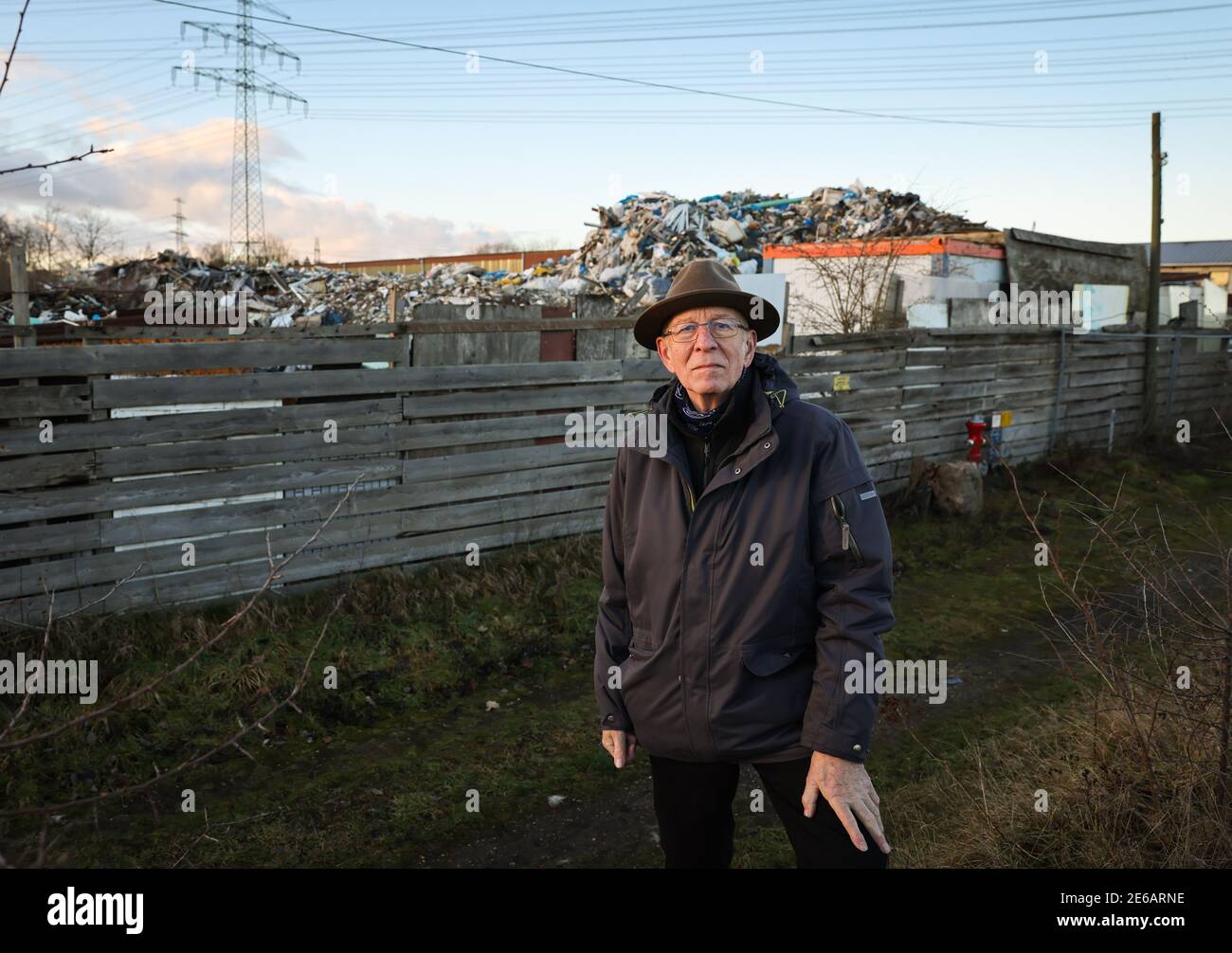 Norderstedt, Germany. 26th Jan, 2021. Winfried Günnemann, a lawyer, is standing in front of an illegal pile of rubbish in the Friedrichsgabe industrial estate in Norderstedt. Up to six metres high, rubbish such as building rubble, tar paper, insulating materials, asbestos and other materials are piled up on a plot of land where a container service was only allowed to temporarily store certain materials. Credit: Christian Charisius/dpa/Alamy Live News Stock Photo