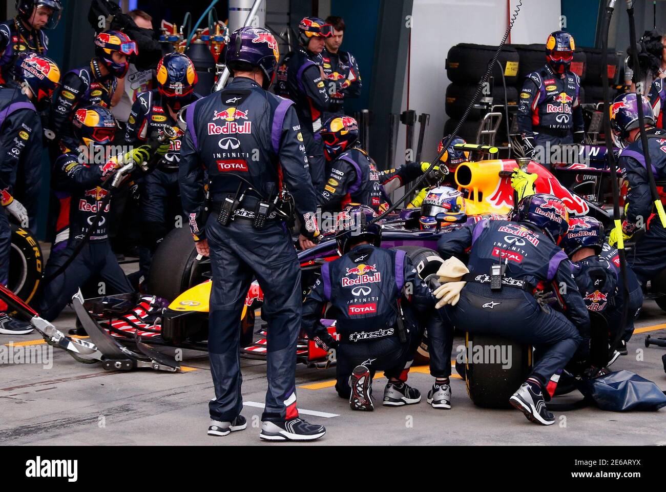 Red Bull Formula One team mechanics perform a pit stop on the car driven by  Daniel Ricciardo of Australia during the Australian F1 Grand Prix at the  Albert Park circuit in Melbourne