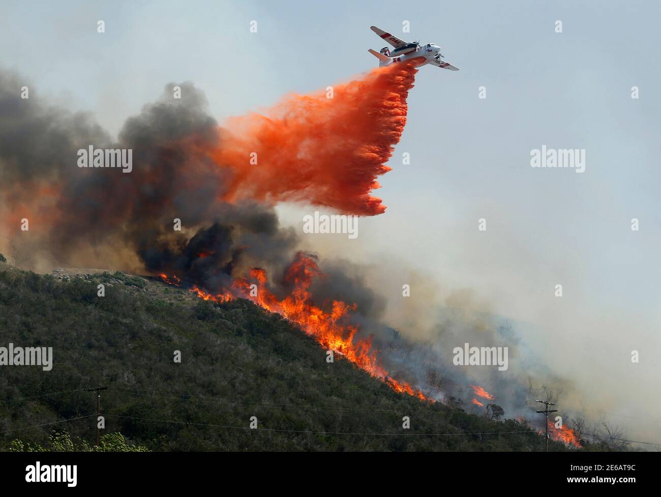 A water bomber makes a drop on flames burning on a hillside as the Cocos Fire continues in San Marcos, California May 15, 2014. Wildfires were raging in southern California on Thursday, keeping thousands of residents and students away from their homes after San Diego county officials maintained evacuation advisories. REUTERS/Mike Blake    (UNITED STATES - Tags: ENVIRONMENT DISASTER) Stock Photo
