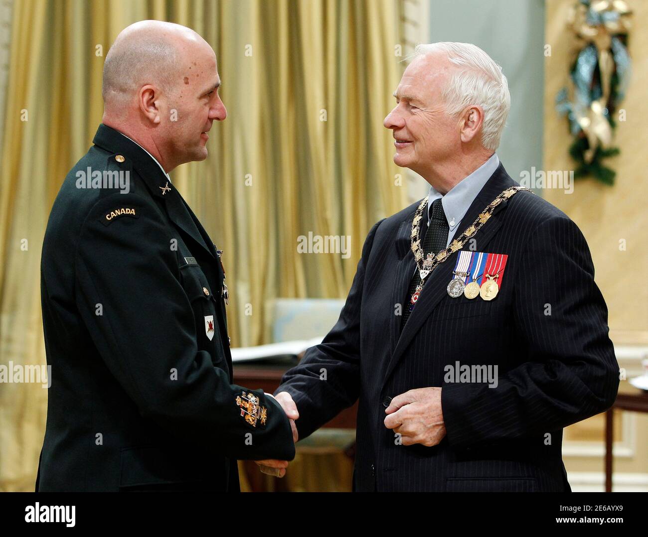 Canada's Governor General David Johnston (R) congratulates Chief Warrant Officer Armand Vinet for receiving the rank of Member in the Order of Military Merit at Rideau Hall in Ottawa December 9, 2010.     REUTERS/Blair Gable     (CANADA - Tags: POLITICS MILITARY) Stock Photo