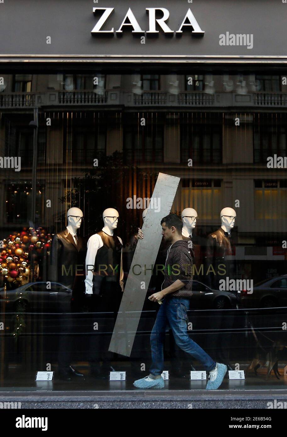 A man works inside a shop window of a Zara store in downtown Madrid  December 12, 2012. Spain's Zara owner Inditex shrugged off sluggish  spending in austerity-wracked Europe on Wednesday, posting a
