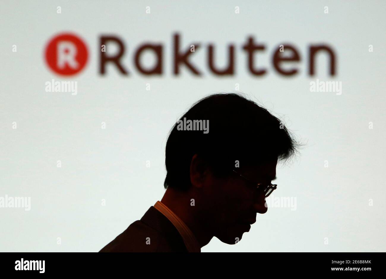 A Man Walks Under A Logo Of Rakuten Inc During A News Conference In Tokyo February 14 14 Japanese E Commerce Company Rakuten Inc Said On Friday It Will Buy Instant Messaging App