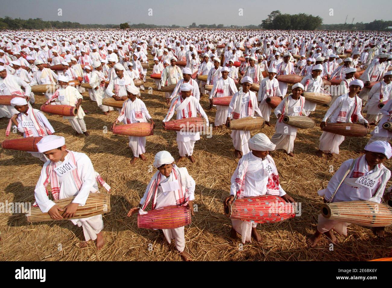 People in traditional attires play their drums during an attempt to enter the Guinness Book of World Record at a field in Titabar town in the northeastern Indian state of Assam January 6, 2013. A total of 14,833 Assamese people on Sunday attempted to enter the Guinness Book of World Record by playing the drums for 15 minutes non stop, organisers said. REUTERS/Utpal Baruah (INDIA - Tags: ENTERTAINMENT SOCIETY) Stock Photo