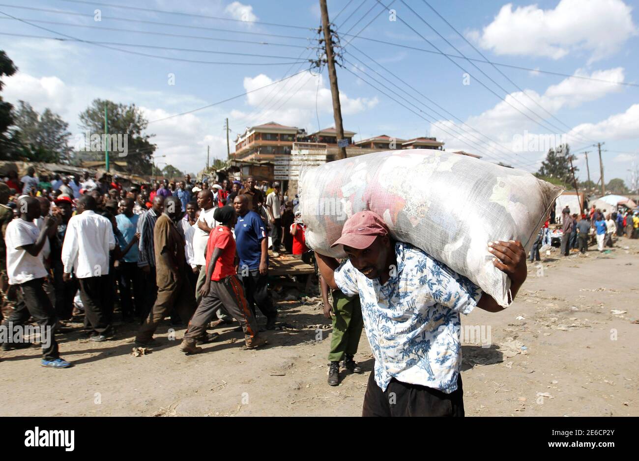 A trader carries a bag of second-hand clothes as he flees the scene of a twin explosion at the Gikomba open-air market in Kenya's capital Nairobi May 16, 2014. The death toll in twin blasts on Friday in the Kenyan capital Nairobi rose to at least 10 with close to 70 people wounded, the National Disaster Operations Centre said. REUTERS/Thomas Mukoya (KENYA - Tags: CRIME LAW CIVIL UNREST) Stock Photo