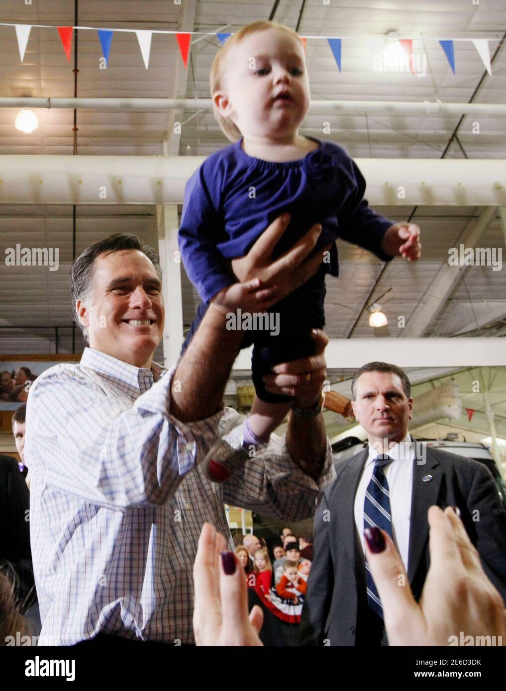 Republican presidential candidate Mitt Romney hands Madison Busch, 1, to her mother after a campaign event at an RV dealer in Loveland, Colorado February 7, 2012. The Colorado caucuses take place today. REUTERS/Rick Wilking (UNITED STATES - Tags: POLITICS TPX IMAGES OF THE DAY) Stock Photo