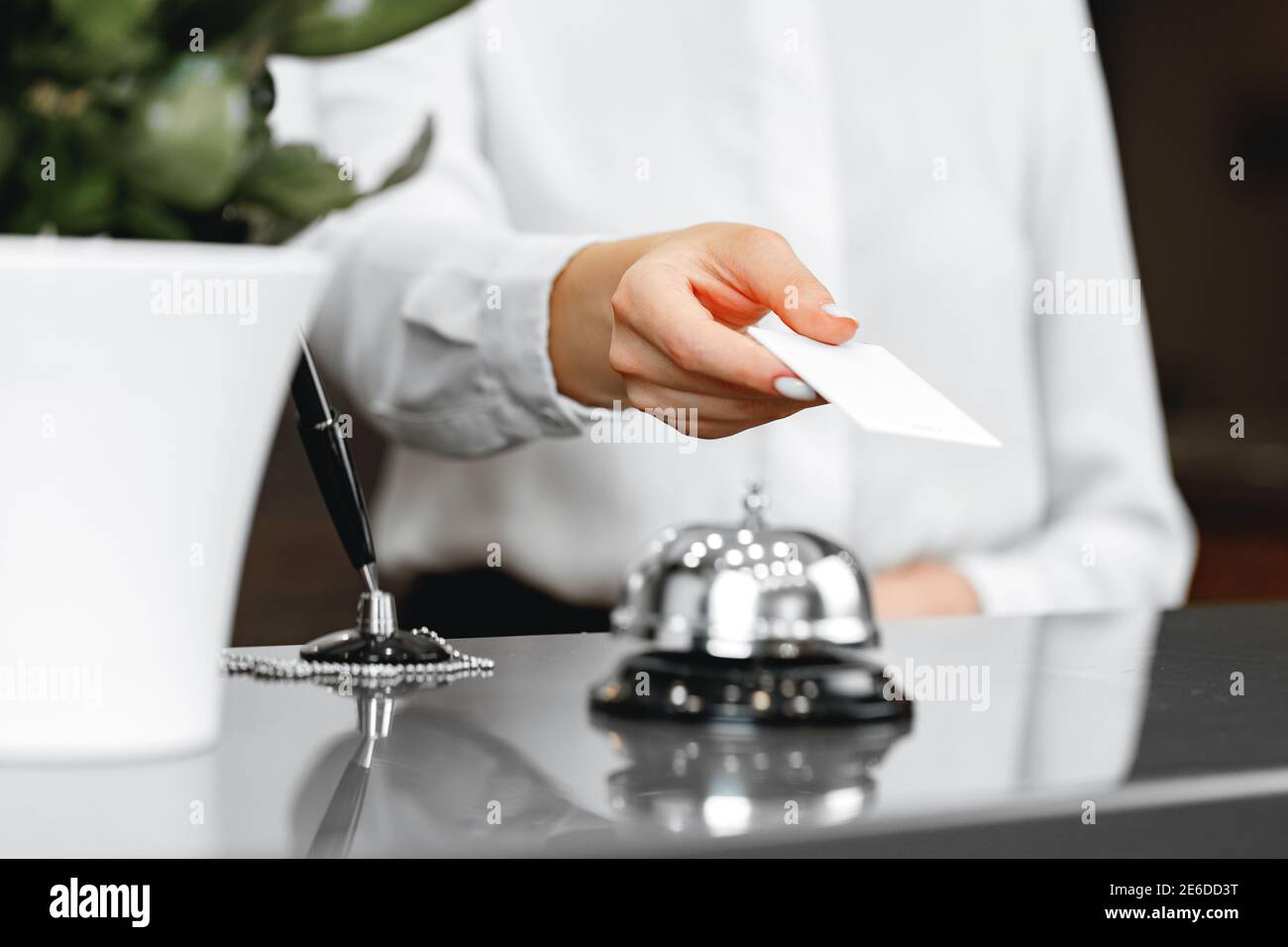 Close up of woman hotel receptionist giving you door key Stock Photo